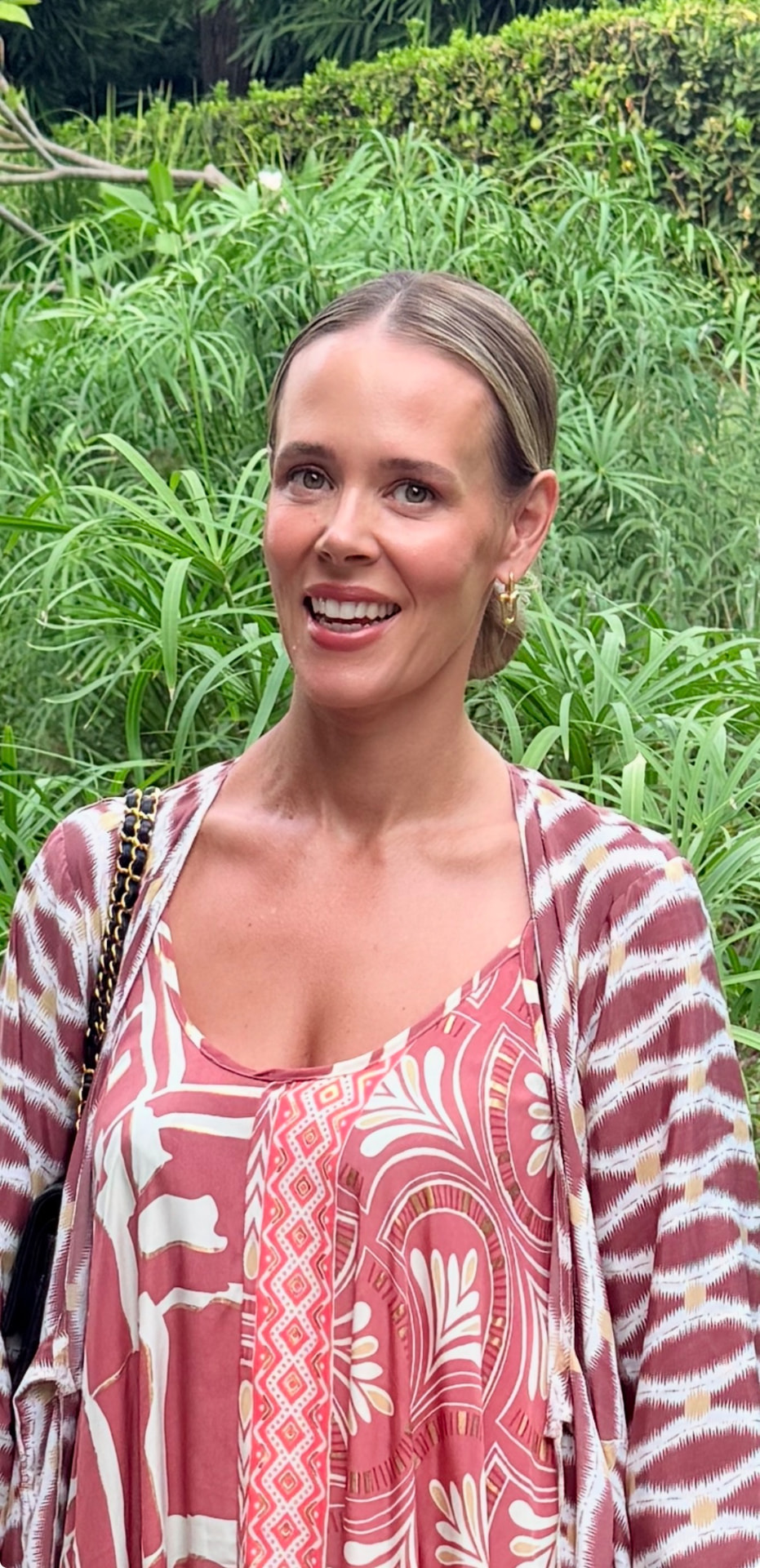 Élise, one of the podcast hosts, smiling outdoors among tall green reeds